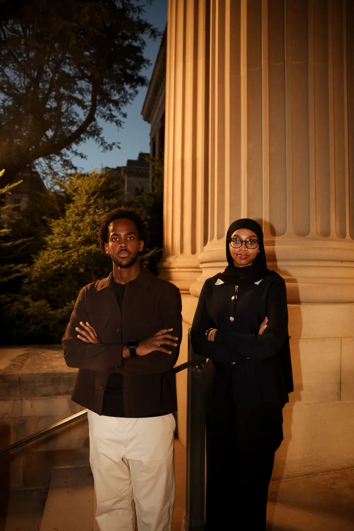 Two students standing outside a campus building at golden hour