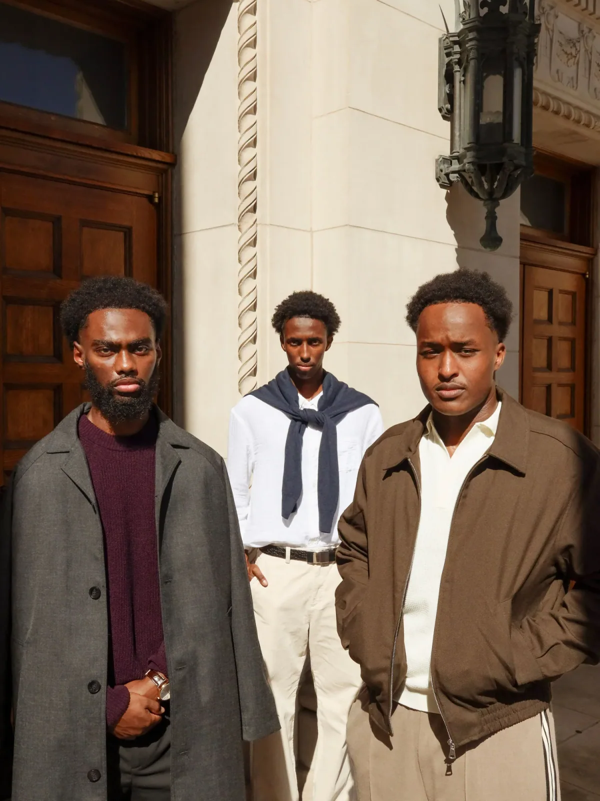 Three students standing together beneath a campus colonnade at dusk