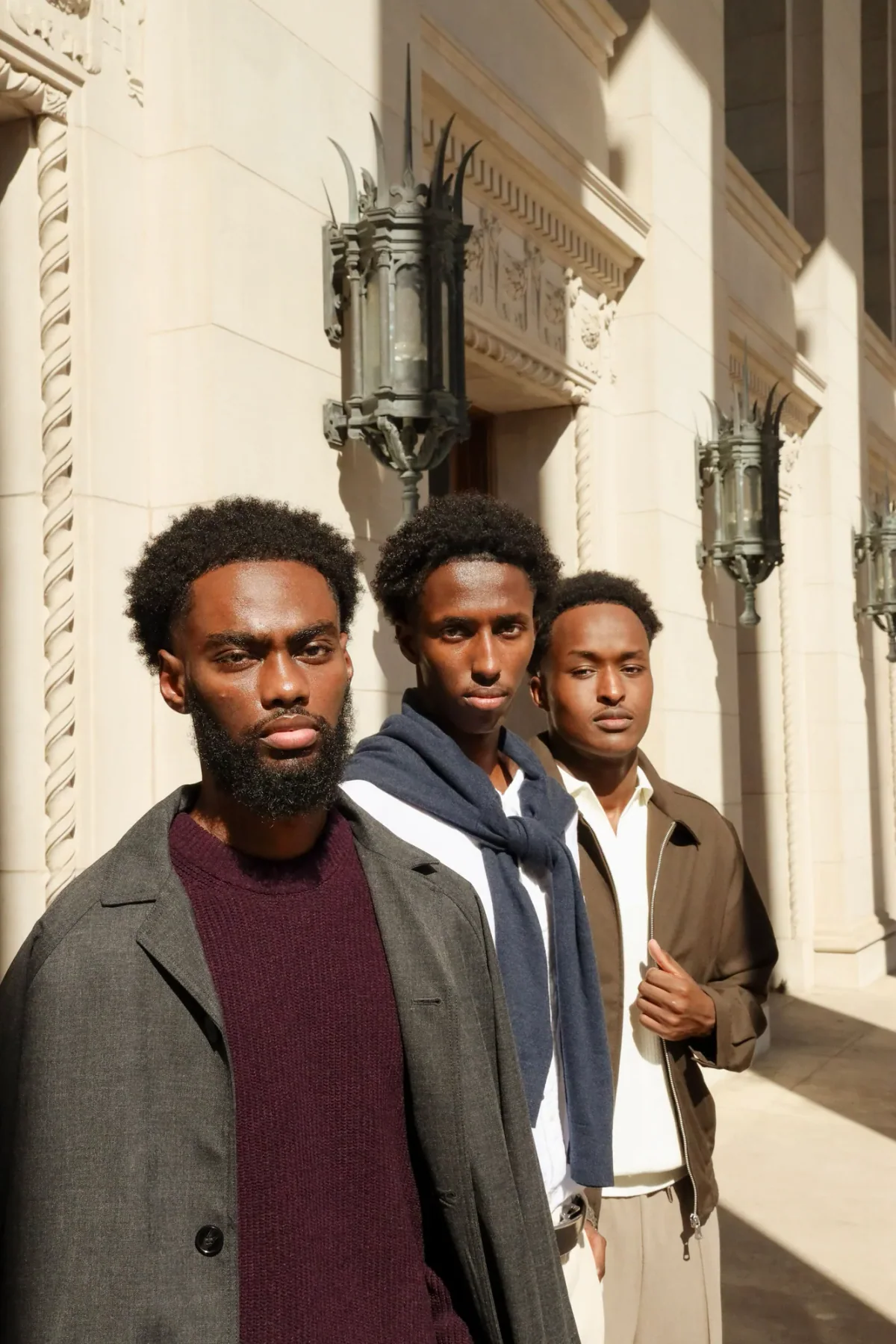 Four students gathered and talking outside a columned entrance